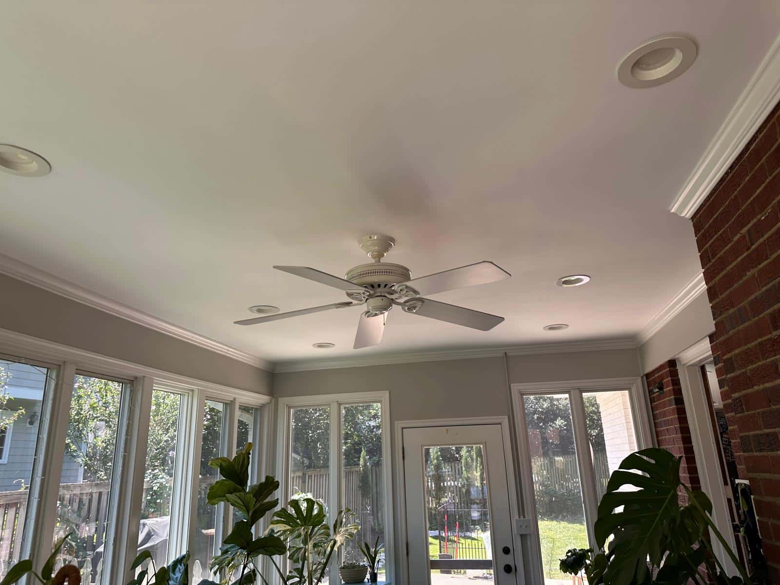 Old white 5-blade ceiling fan in a sunroom before replacement