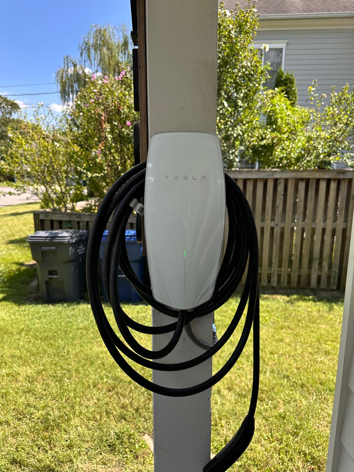 Tesla Wall Connector mounted on an outdoor post with cable coiled neatly — EV charger installation