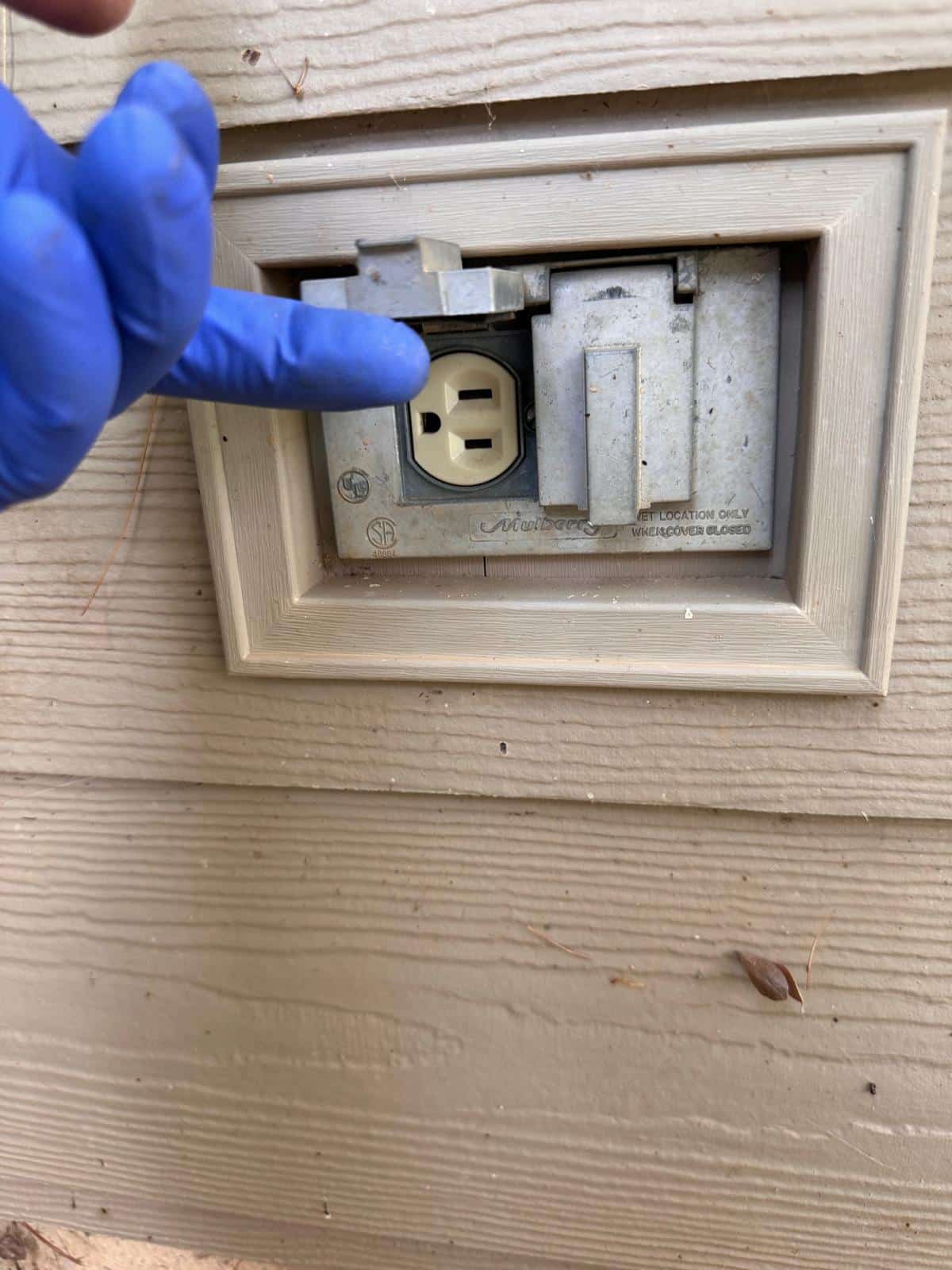 Old outdoor outlet with dirty Mulberry flip cover before replacement