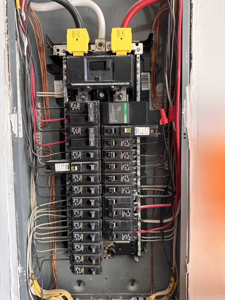 Completed 200-amp electrical panel upgrade by EV-Electric Services in Fairfax, Virginia — Square D panel with labelled circuits and whole-home surge protector