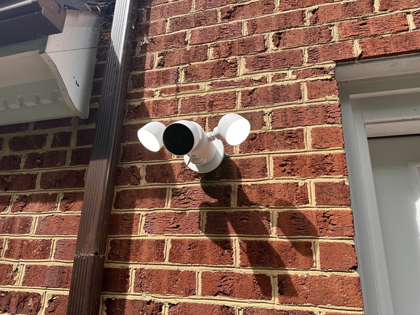 Floodlight camera mounted and wired onto the brick exterior of a Northern Virginia home